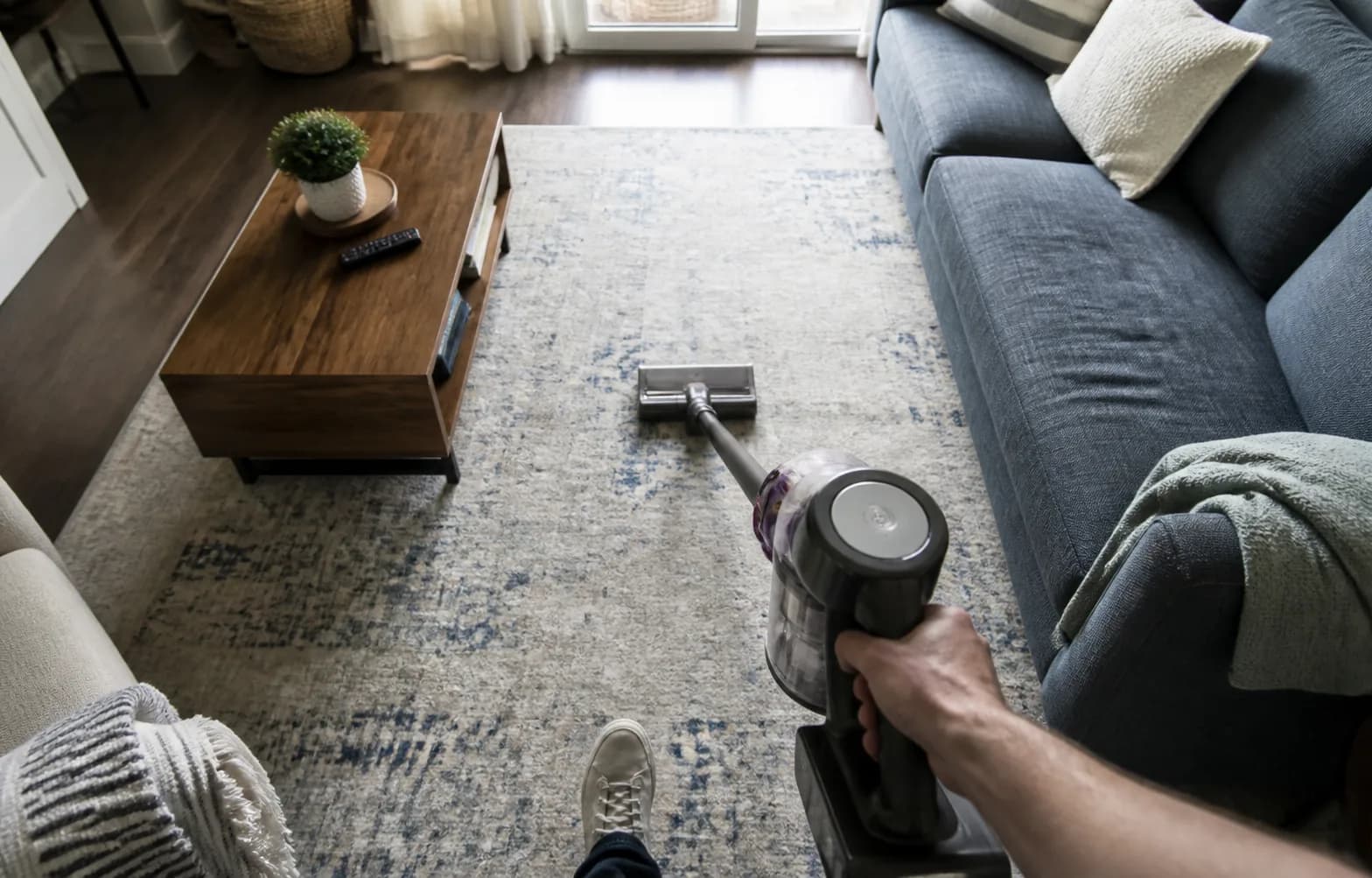 First-person view of vacuuming a living-room rug